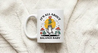 Mug Balancing Cat on Unicycle with Text It's All About Balance Baby
